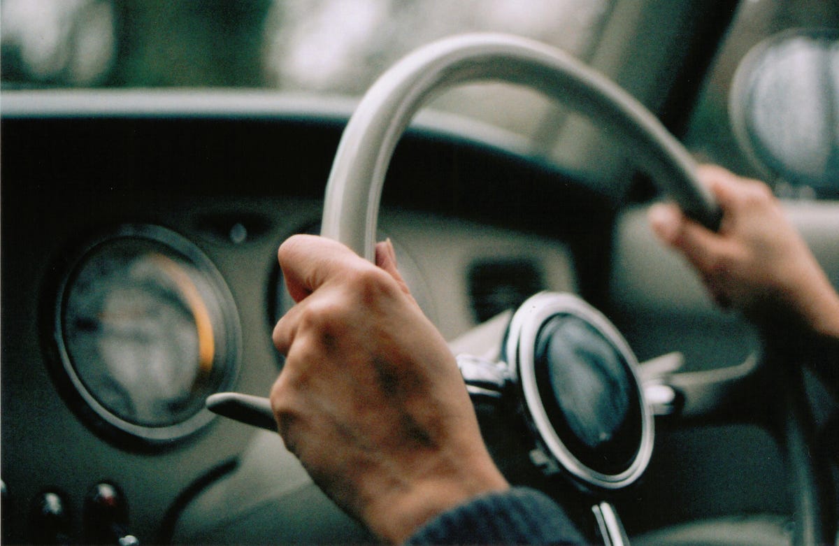 Interior shot of two hands holding a steering wheel